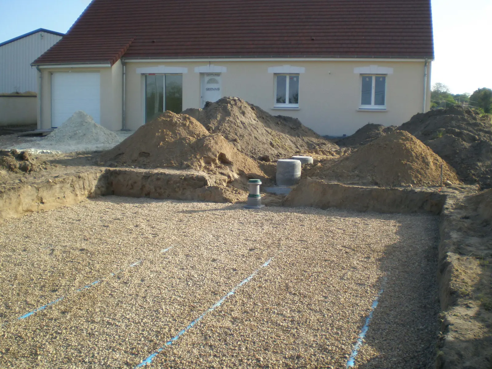 Chantier d'installation d'un assainissement non collectif devant une maison
